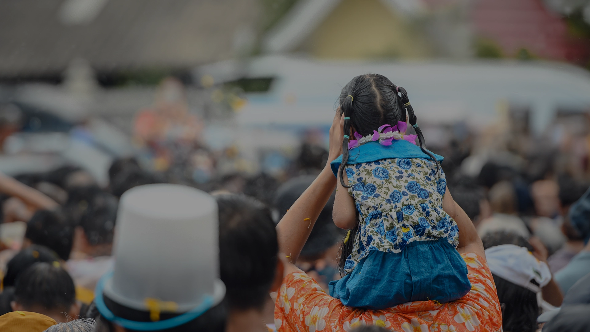 Child on a parents shoulders at an event